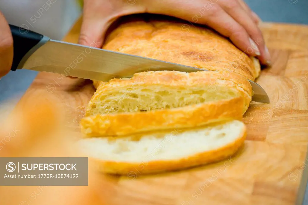 Close up of chef slicing bread