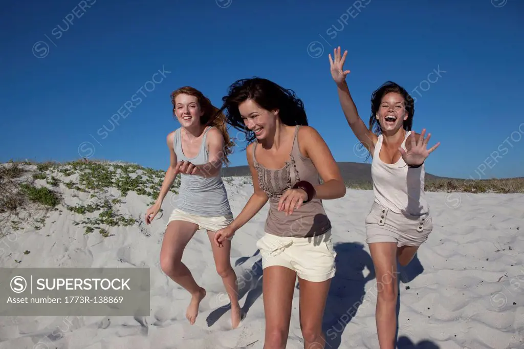 Three girls running towards camera