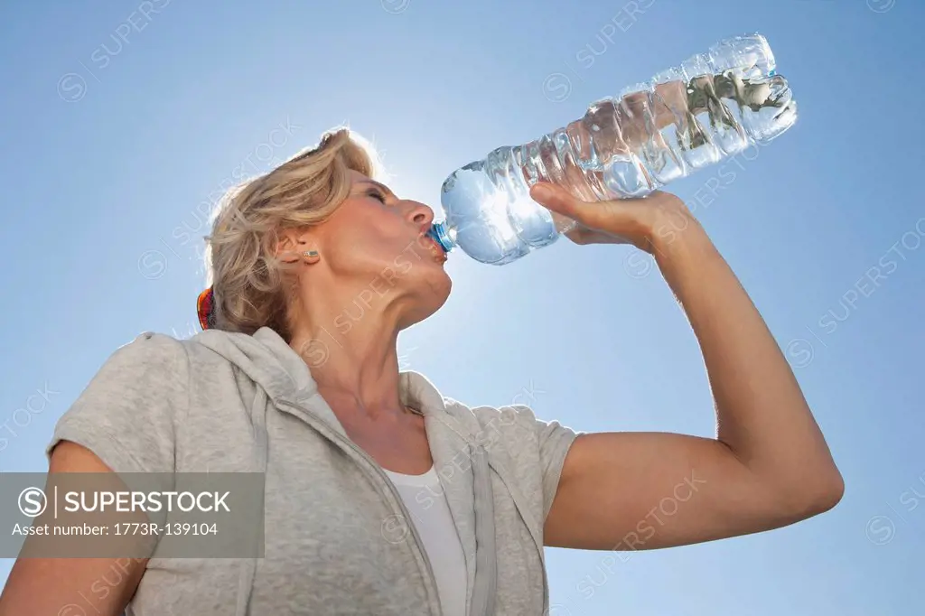Mature woman drinking water from bottle