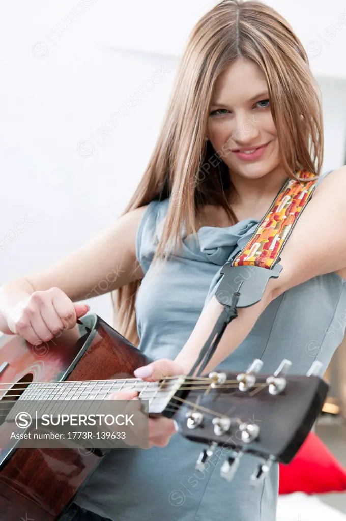 Girl playing guitar with determination