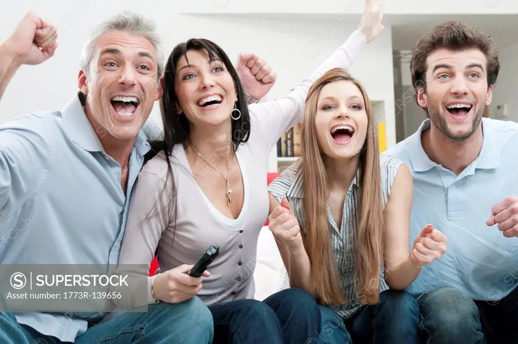 Excited friends watching sport on TV