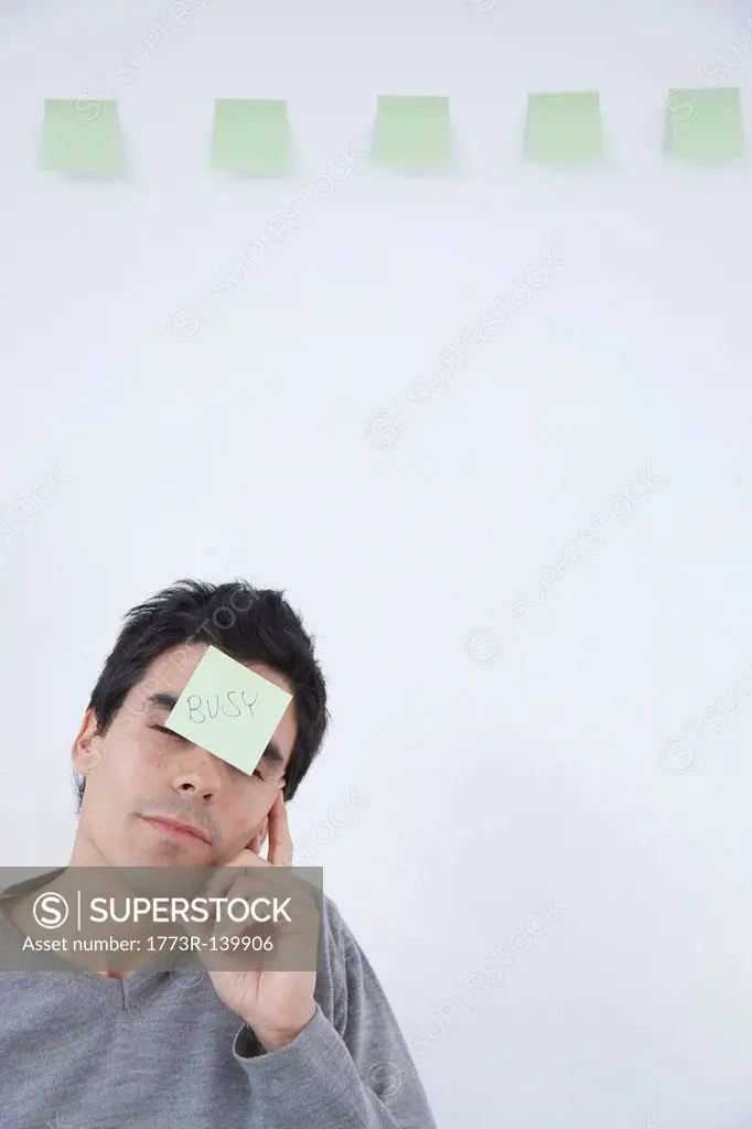 Man with ´busy´ post_it note on his head