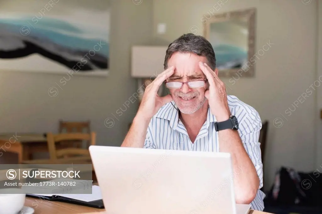 Frustrated businessman using laptop