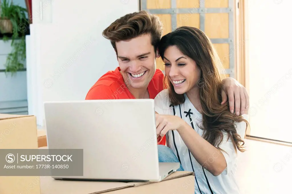 Smiling couple using laptop together