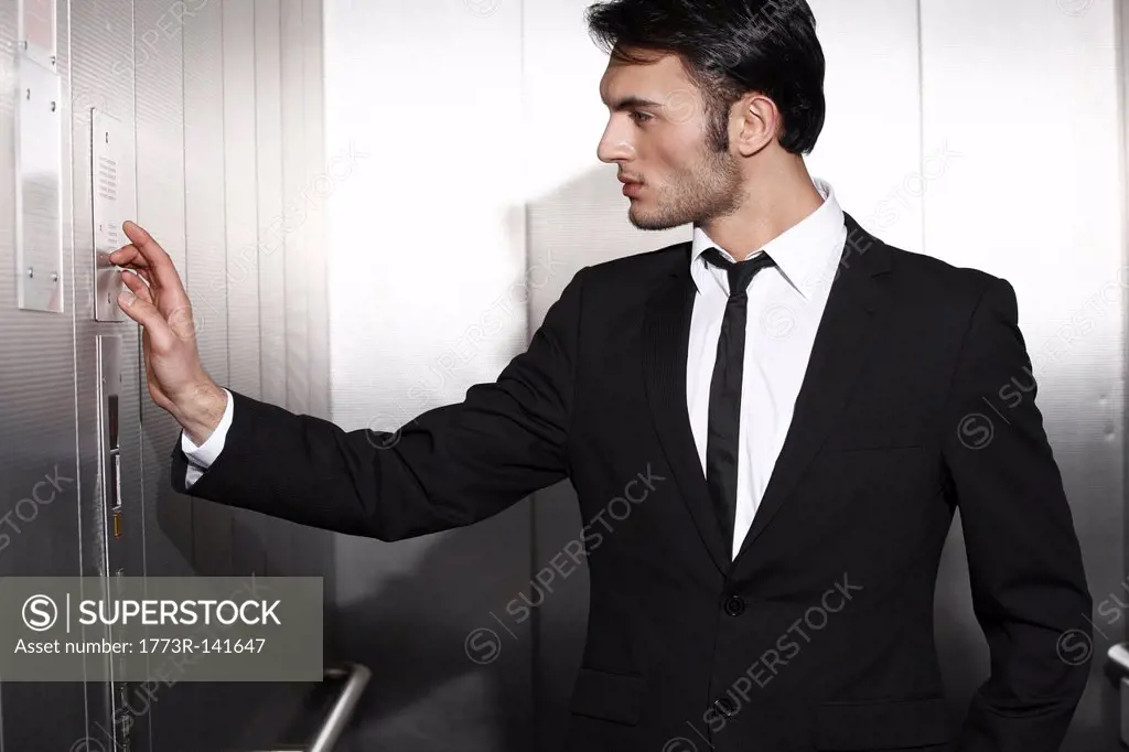 Businessman pressing elevator buttons