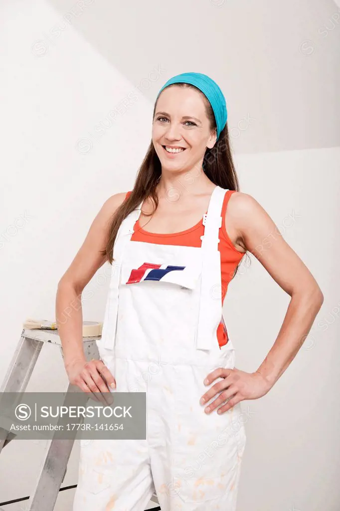 Smiling woman standing by ladder