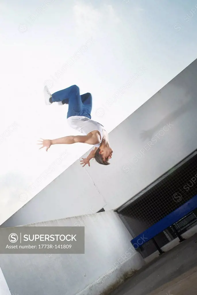 Man jumping on urban rooftop