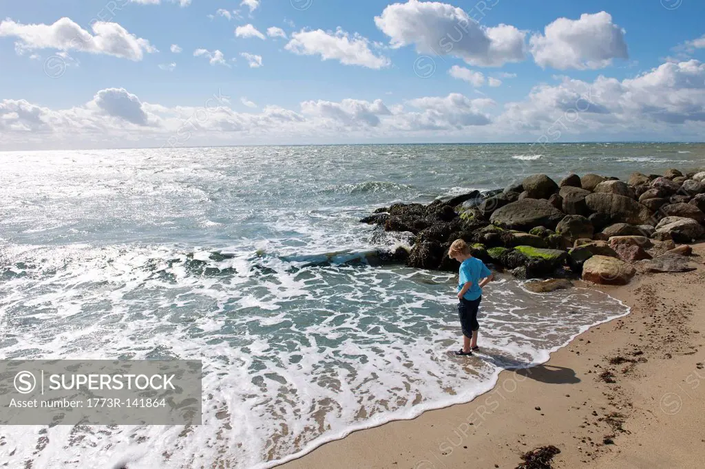 Boy standing in surf at the beach