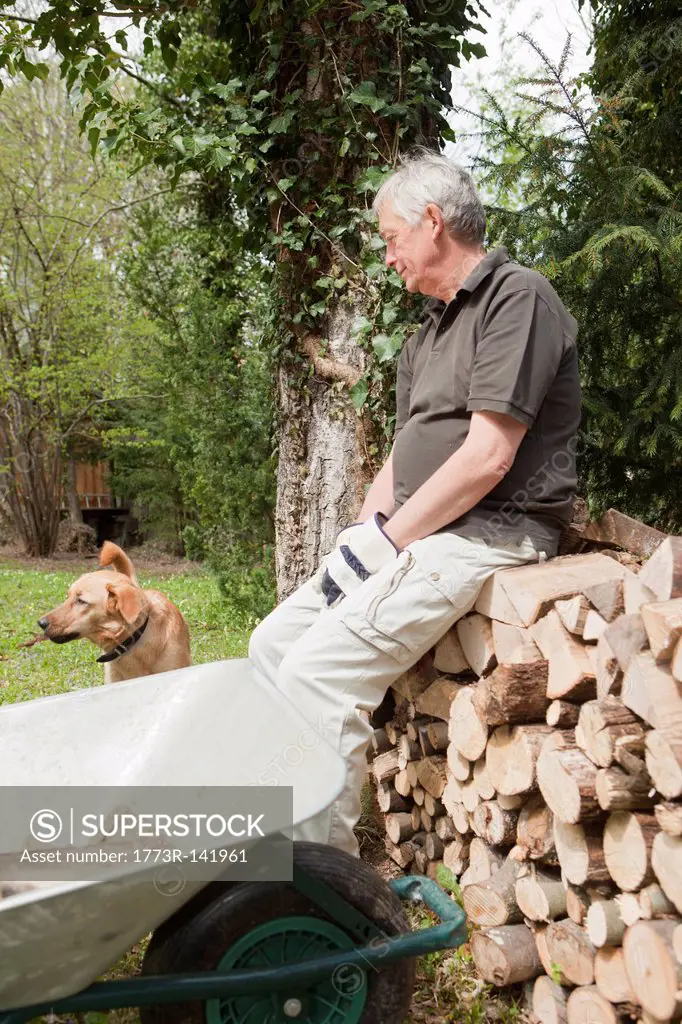 Older man resting with dog in backyard