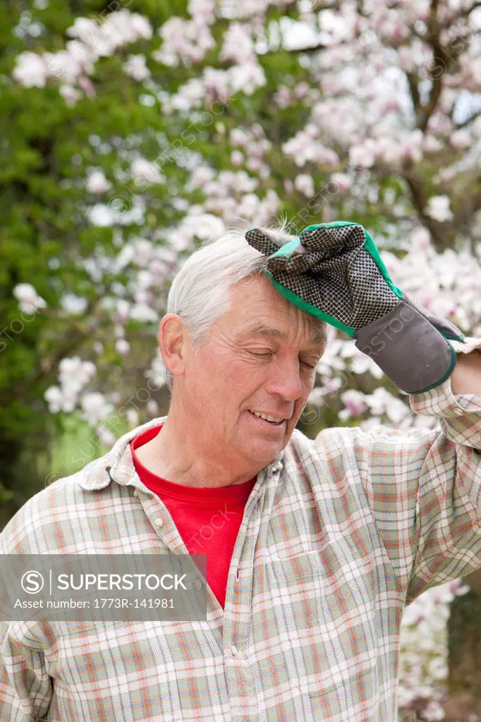 Older man wiping his brow