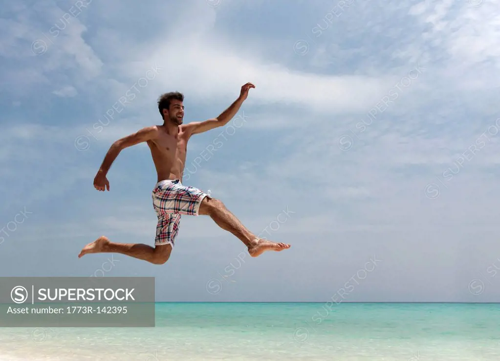 Man jumping on tropical beach