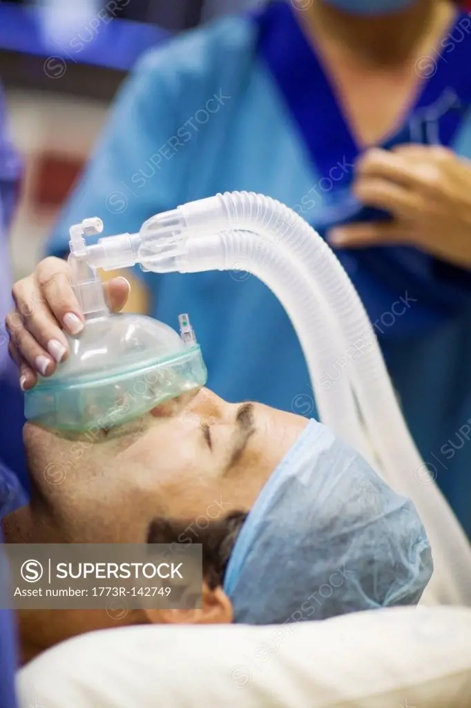 Nurse giving anesthetic gas to patient