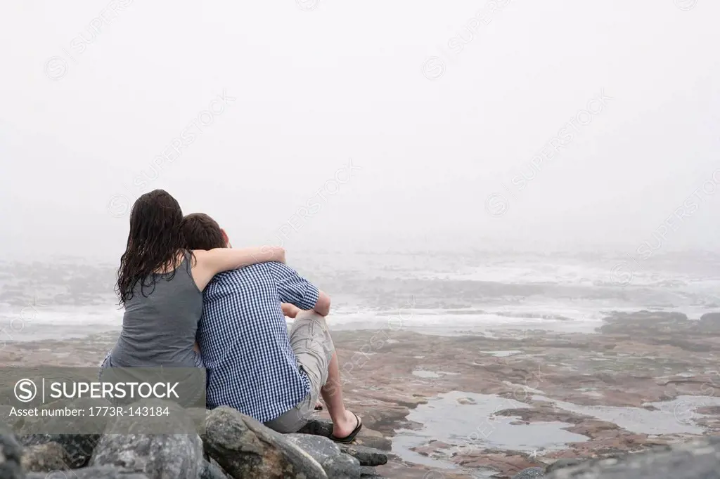 Couple hugging on rocky beach