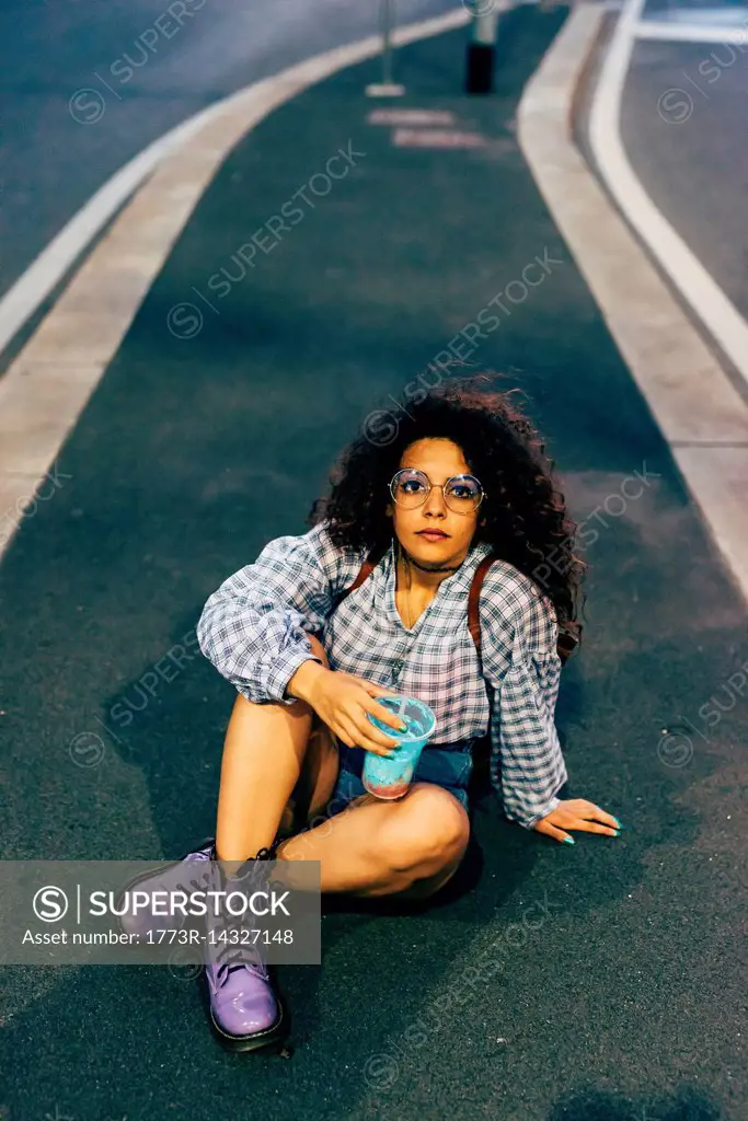 Woman in central reservation in street, Milan, Italy