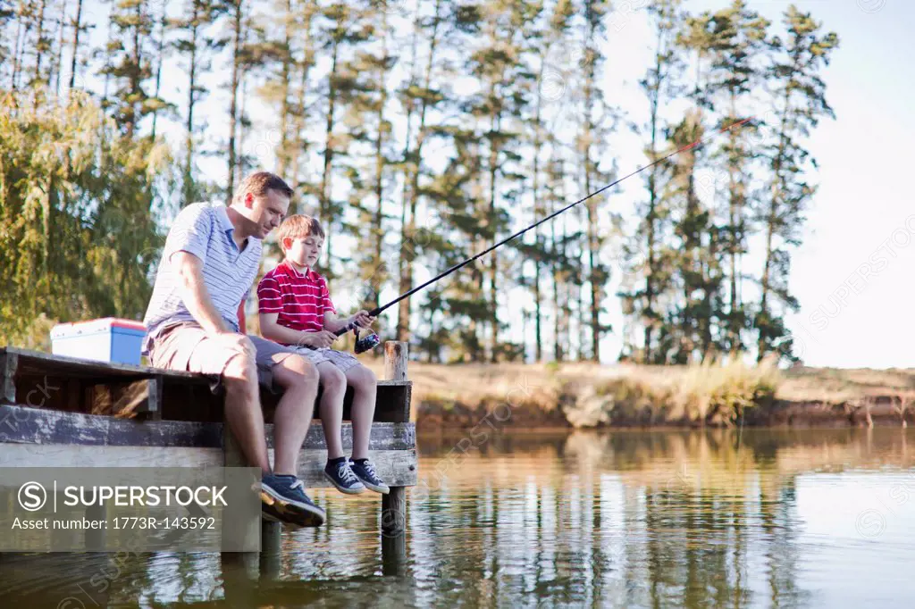Father fishing with son in lake