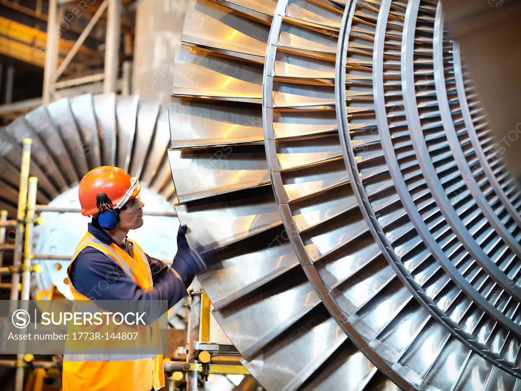 Worker inspects turbine in power station