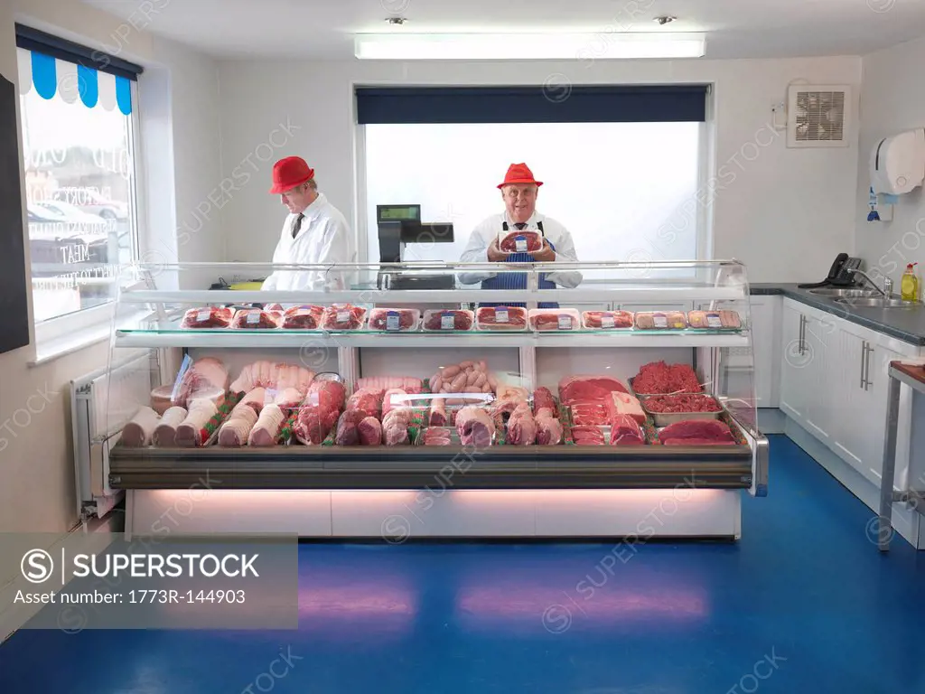 Butcher standing behind meat counter