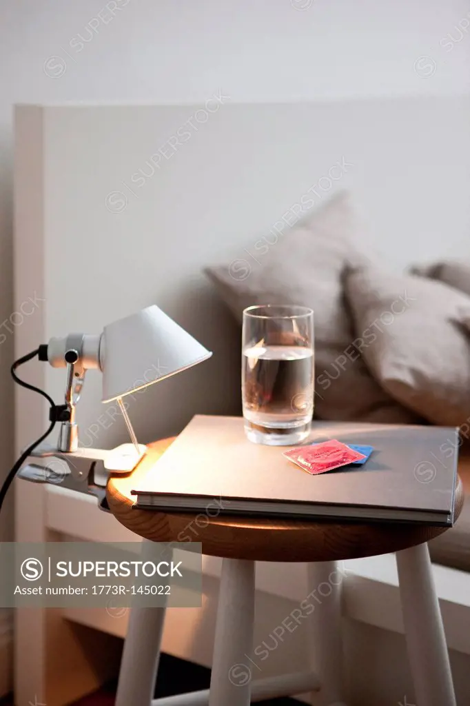 Condoms and water on bedside table