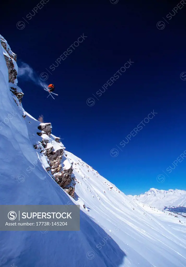 Skier making jump on mountainside