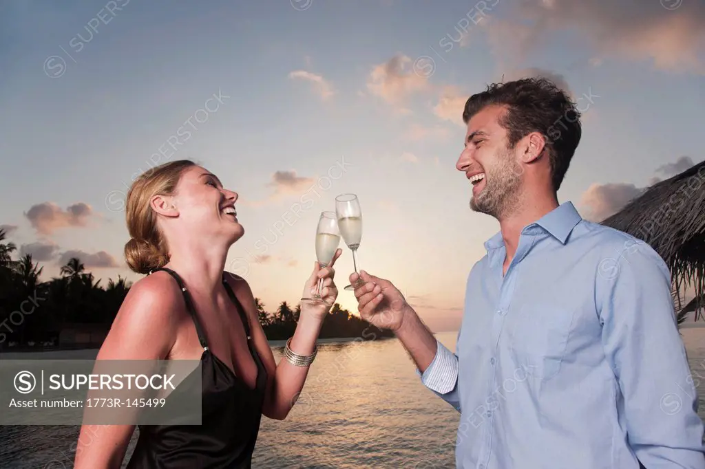Couple toasting each other on dock