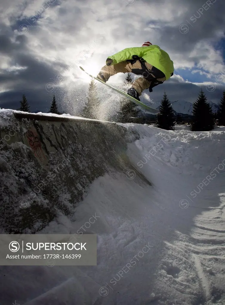 Snowboarder jumping on half_pipe