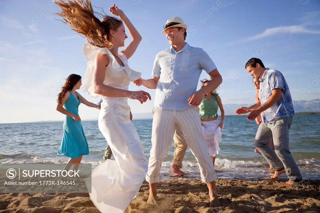 Newlywed couple on beach with friends