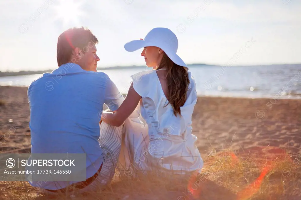 Newlywed couple sitting on beach