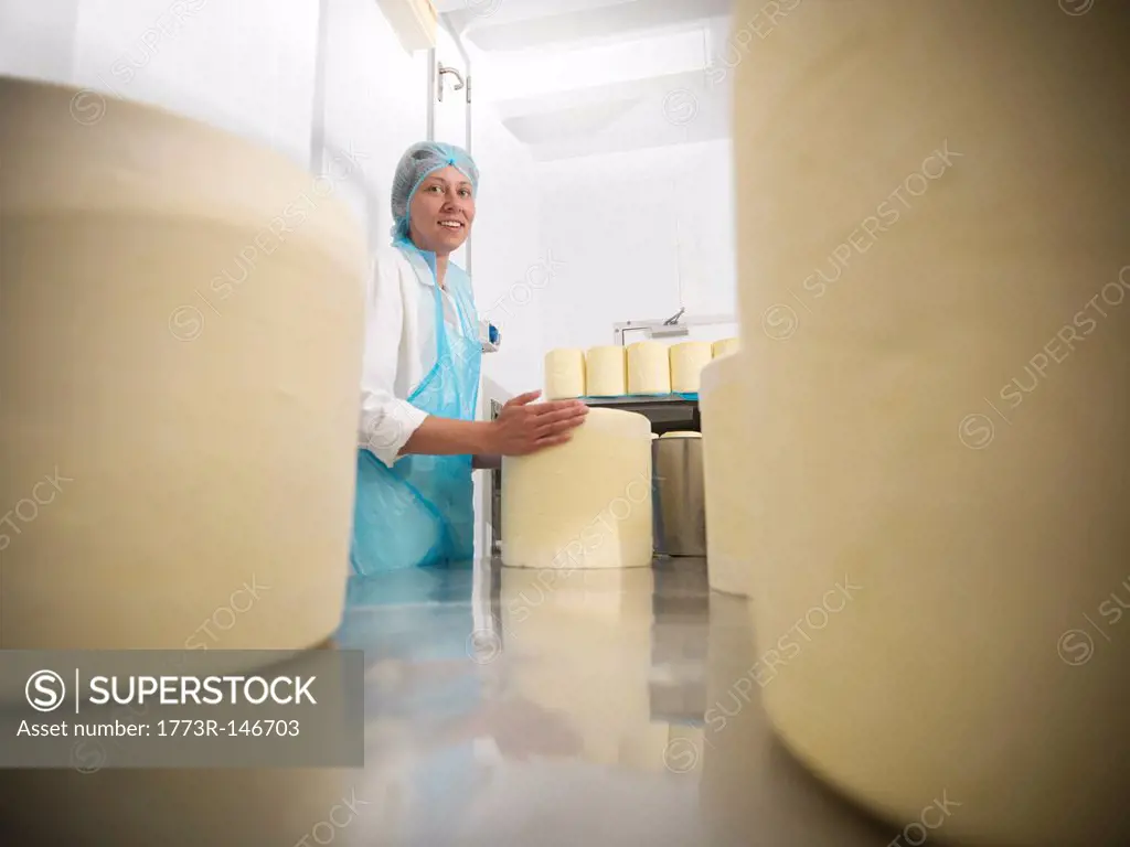 Worker wrapping cheese in factory
