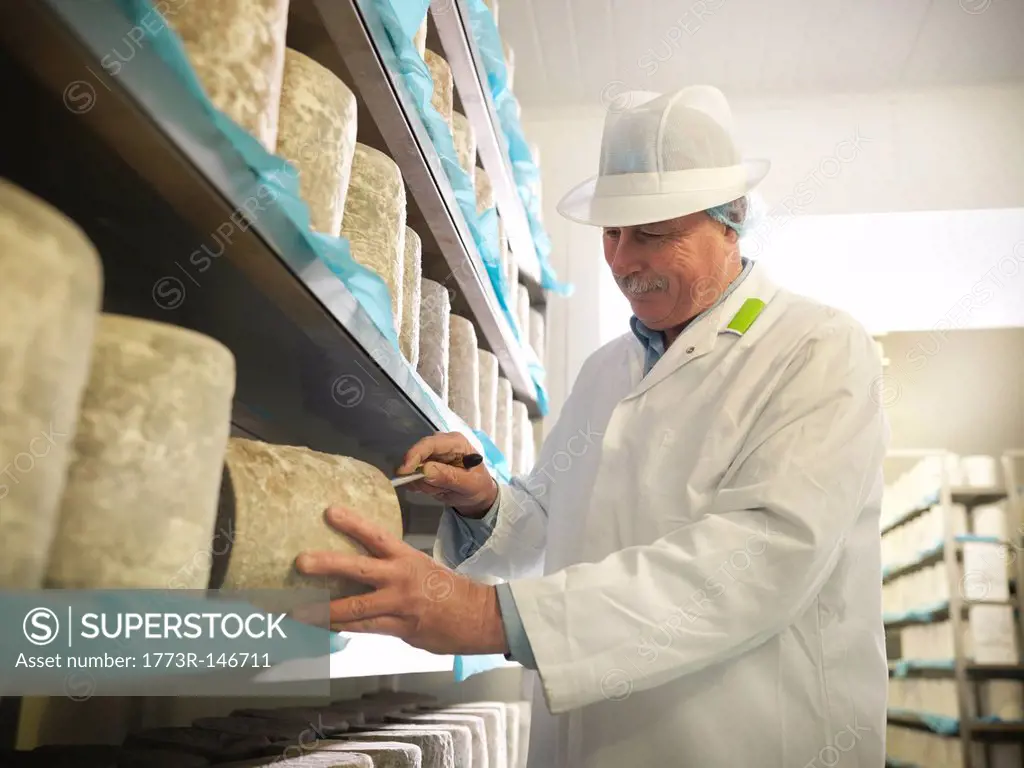 Worker checking blue cheese in factory