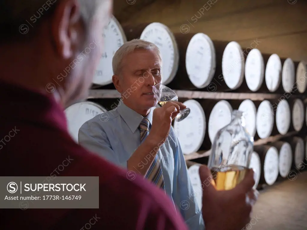 Workers checking whisky in distillery