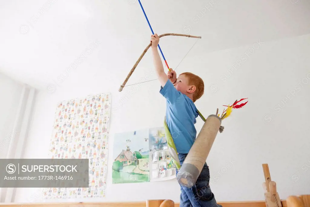 Boy playing with toy bow and arrow