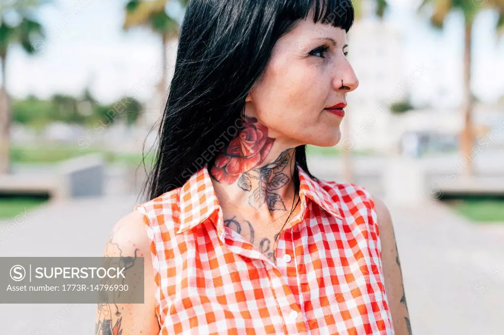 Mature female hipster with tattooed neck, close up
