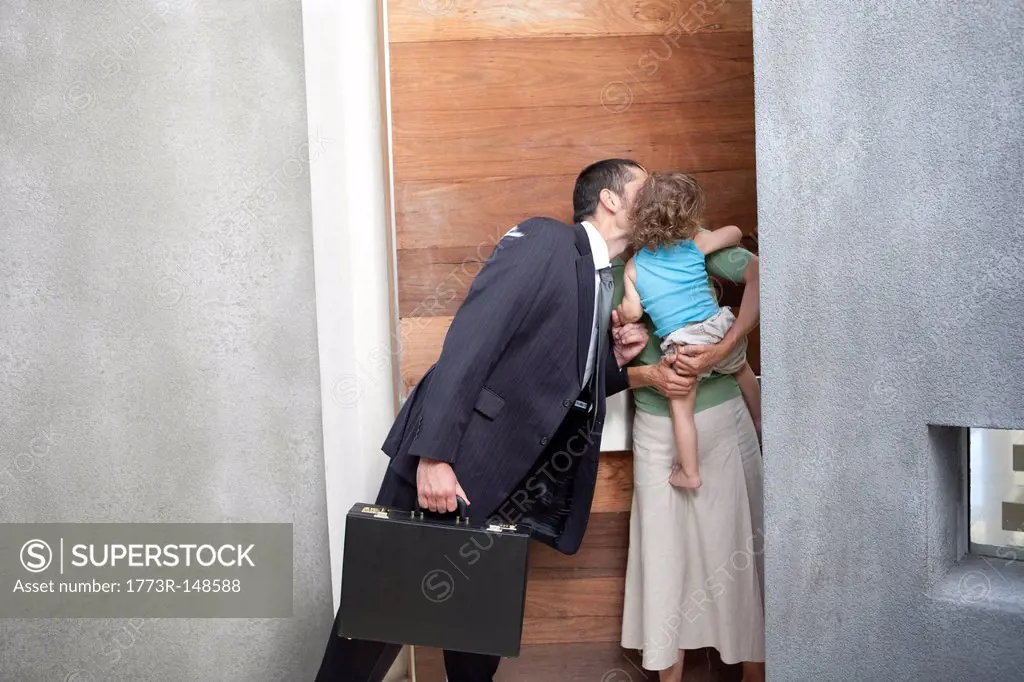 Husband kissing wife before work