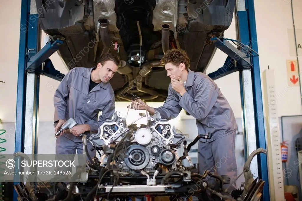 Mechanics working on car engine