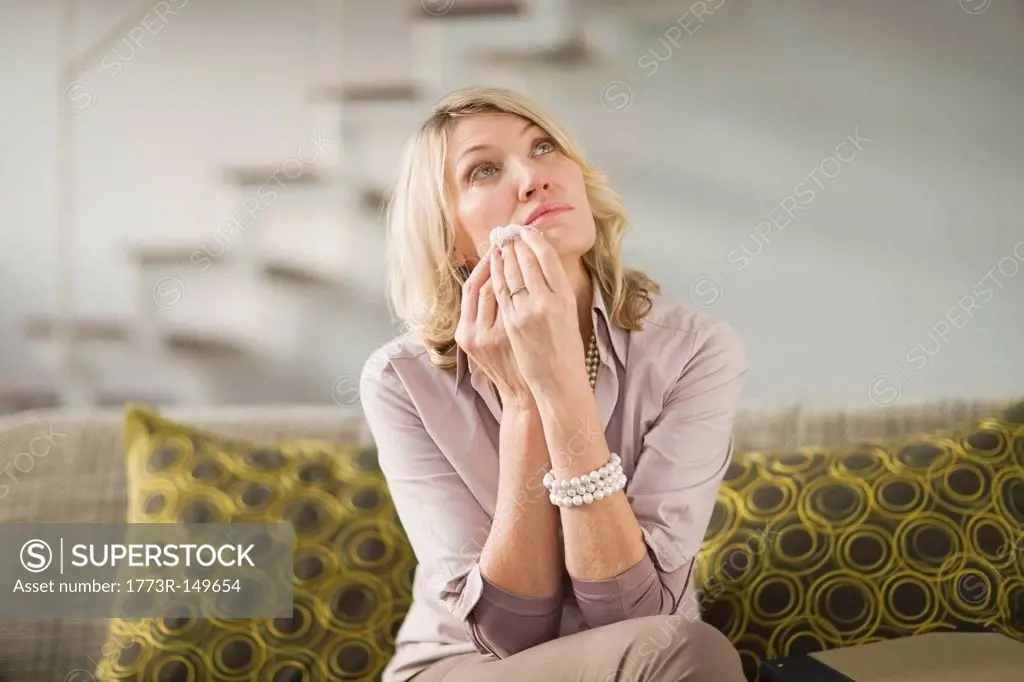 Woman wiping tears from cheeks