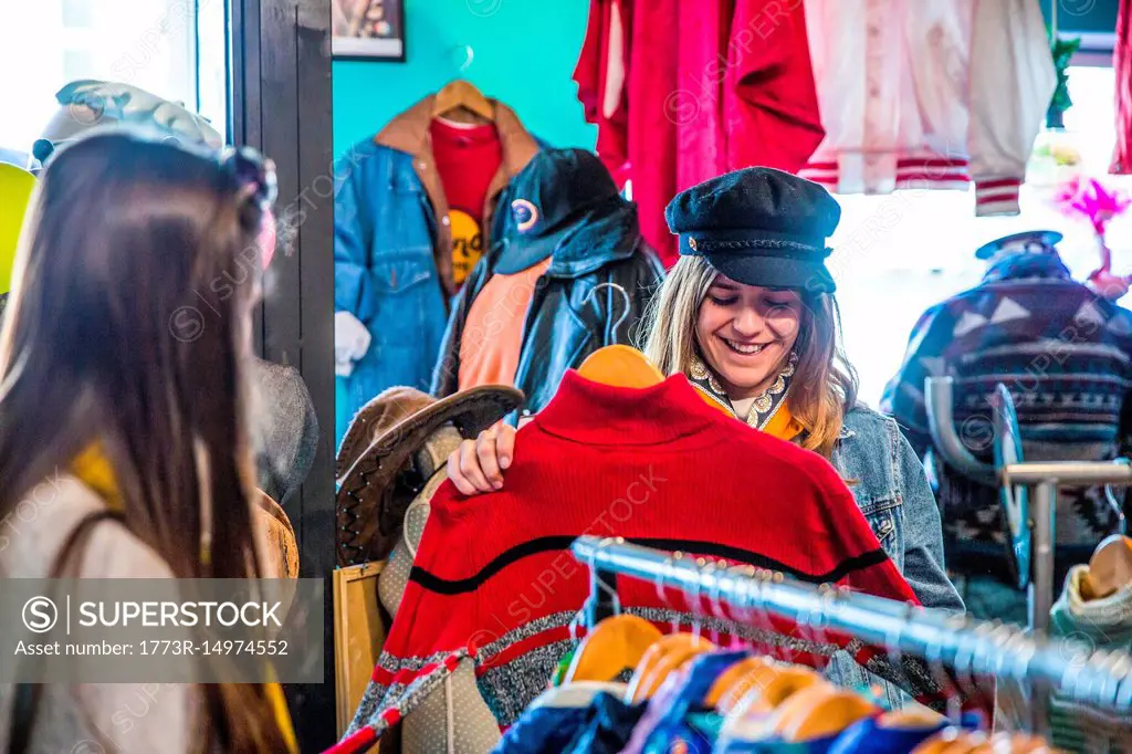 Friends browsing vintage clothes in thrift store