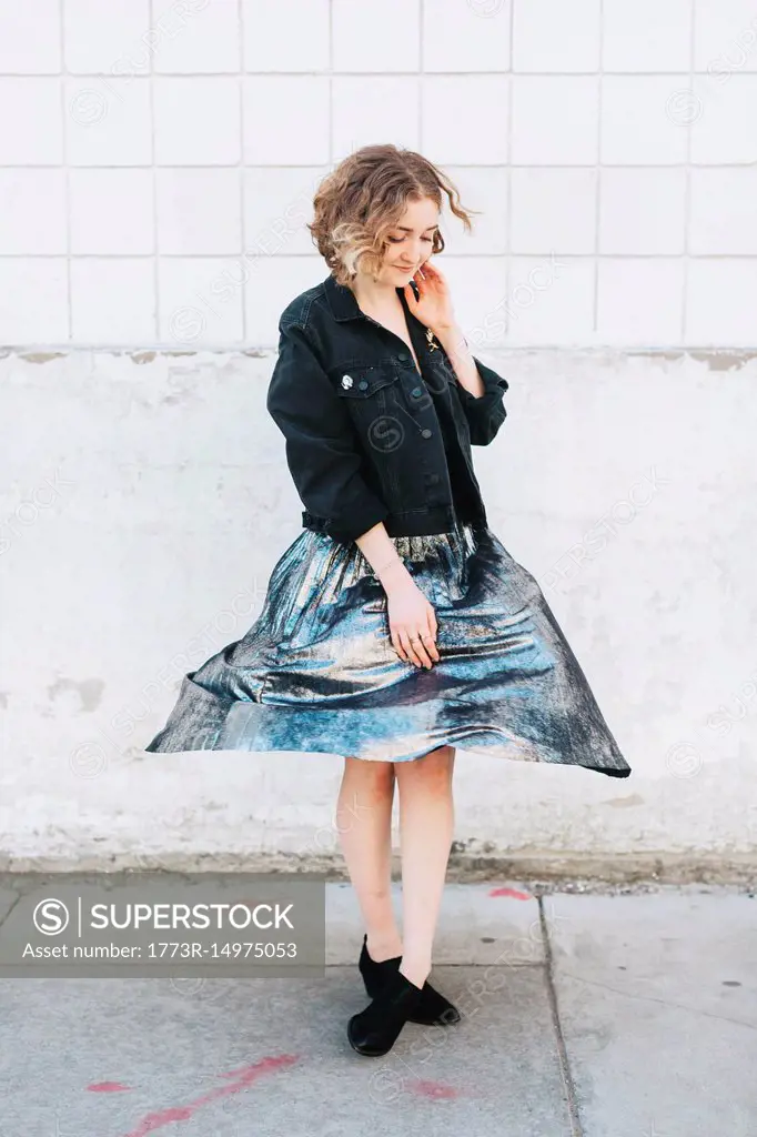 Woman in street twirling metallic skirt