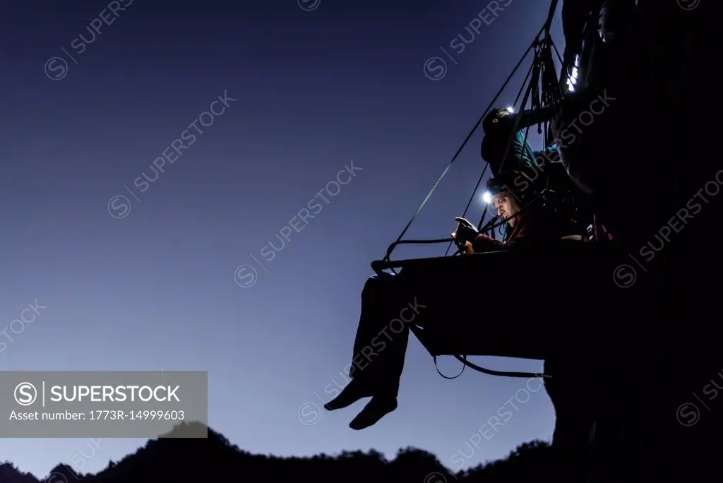 Rock climbers on portaledge, at night, Liming, Yunnan Province, China