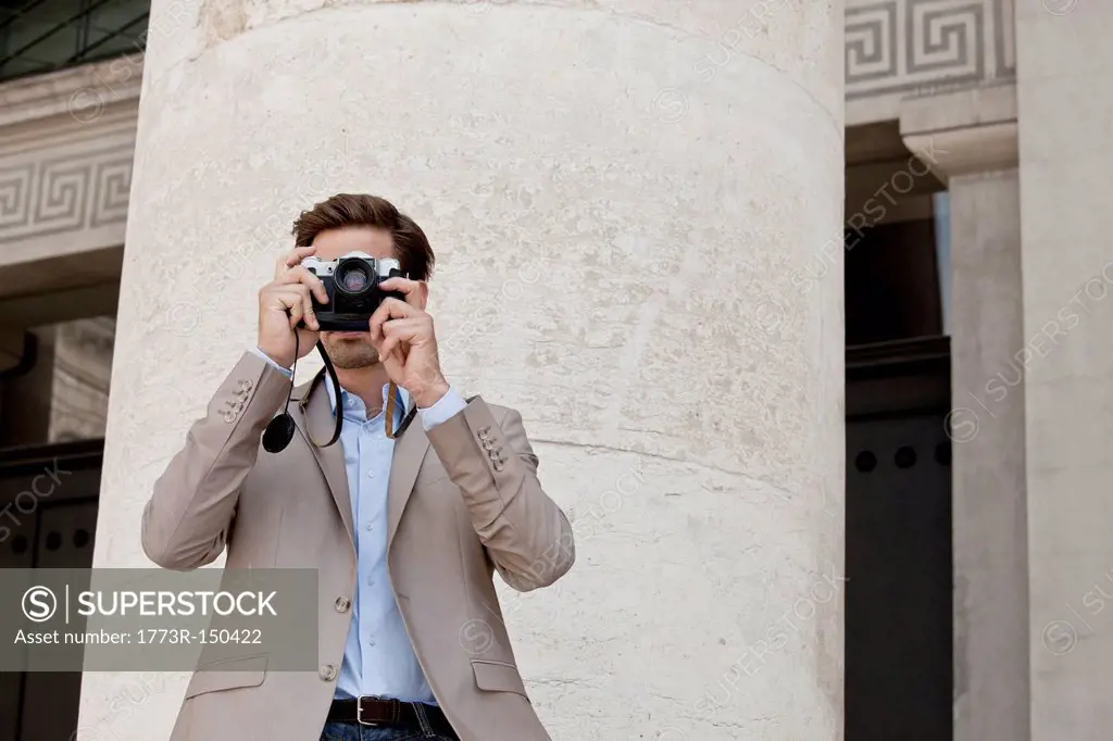 Man taking pictures by columned building