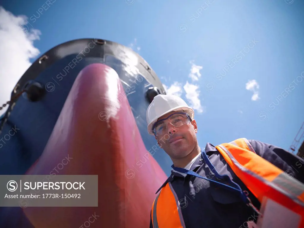 Smiling worker standing by ship