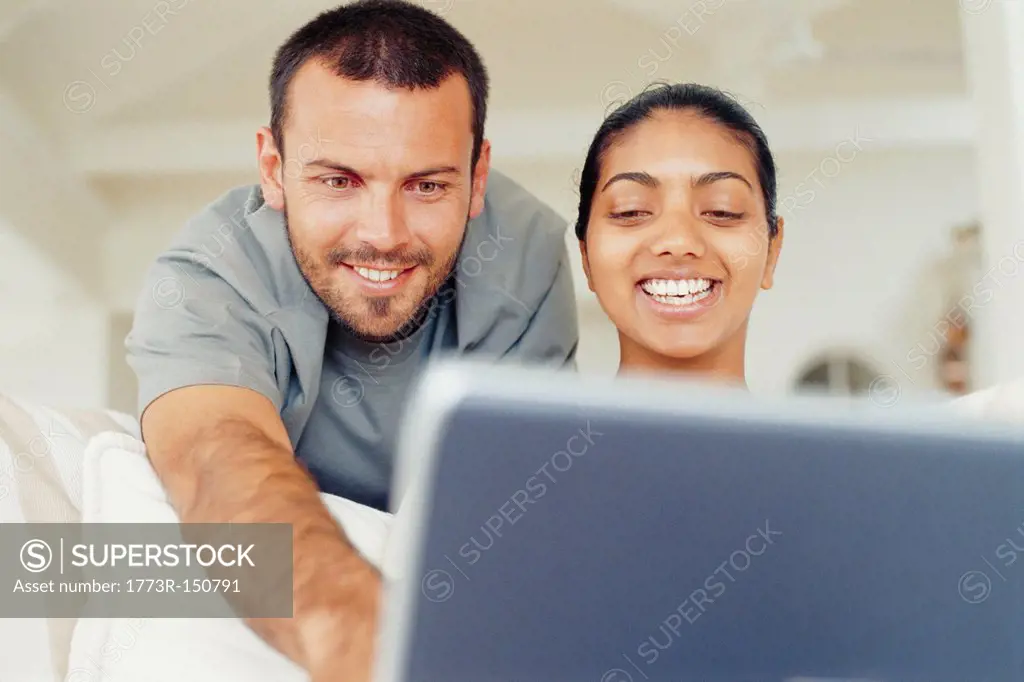 Couple using laptop in living room