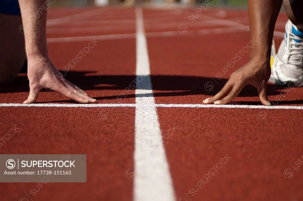 Close up of athletes´ hands on track