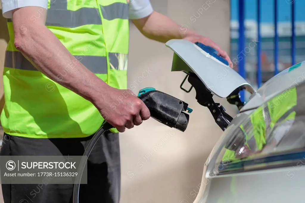 Close up of delivery driver charging electric van