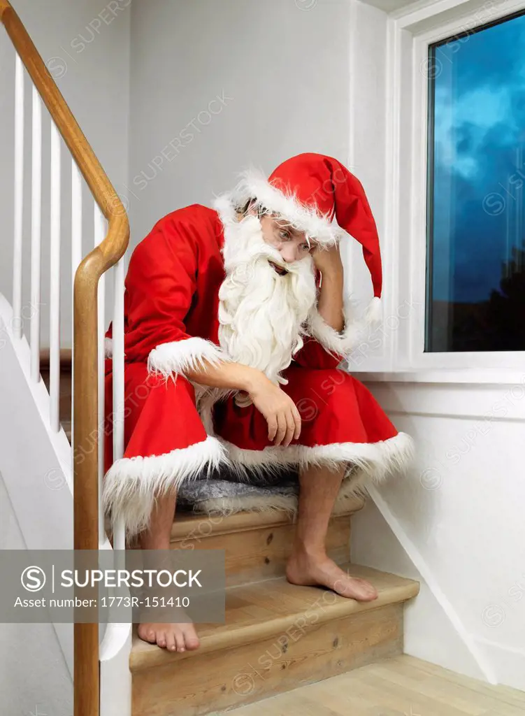 Man in Santa Claus suit sitting on steps