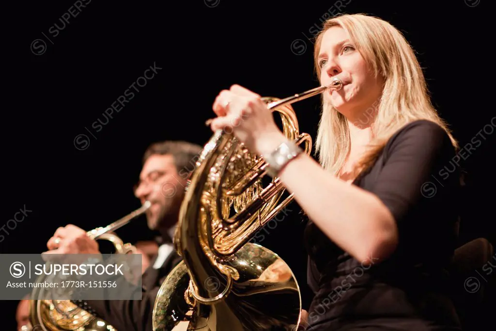 French horn players in orchestra