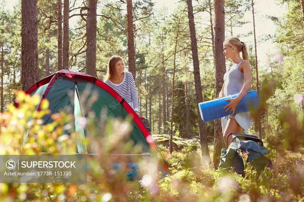 Women setting up campsite in forest