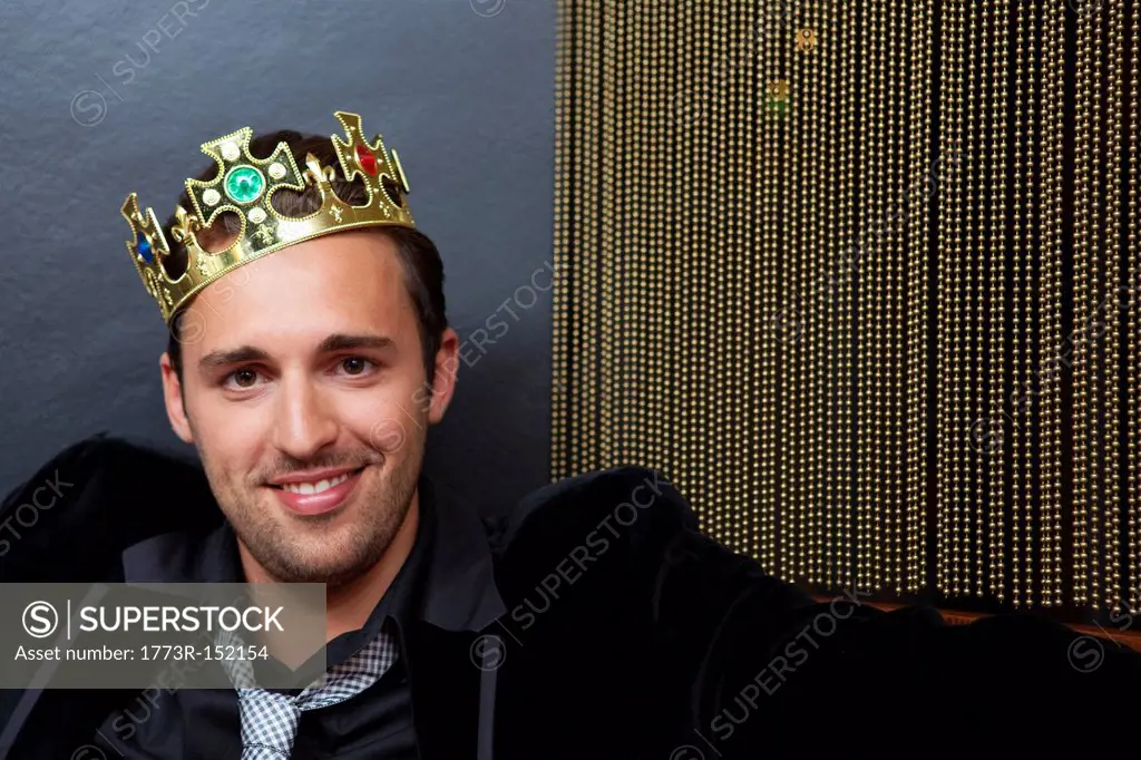 Smiling man wearing plastic crown