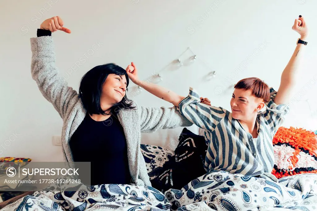 Women in bed arms raised stretching