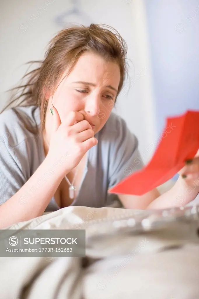 Crying teenage girl reading letter