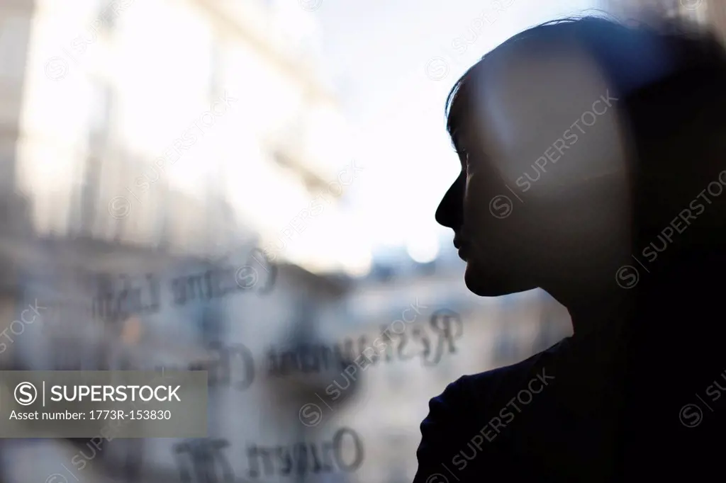 Silhouette of woman reflected in window